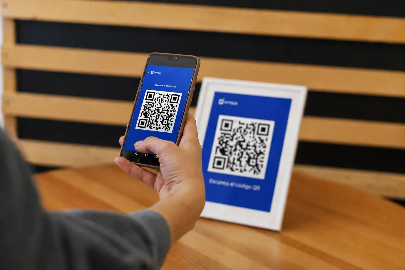 Persona escaneando un código QR de PrestApp en un comercio adherido